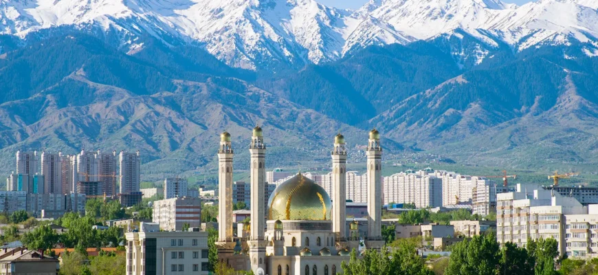 Comparison of modern luxury hotels and residential apartments in Almaty, Kazakhstan, with the Trans-Ili Alatau mountains in the background