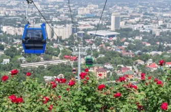 Scenic cable car ascending Kok-Tobe hill with panoramic views of Almaty city and Tien Shan mountains